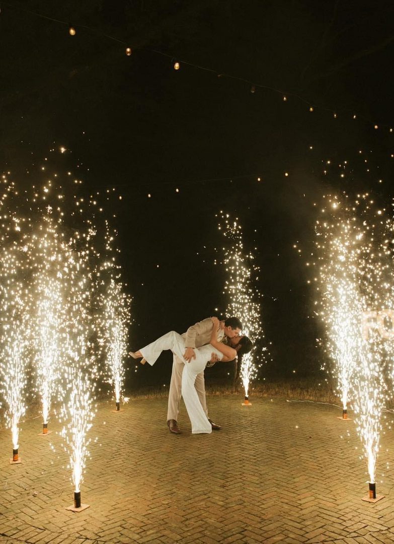 Couple kissing amidst sparkling fireworks.