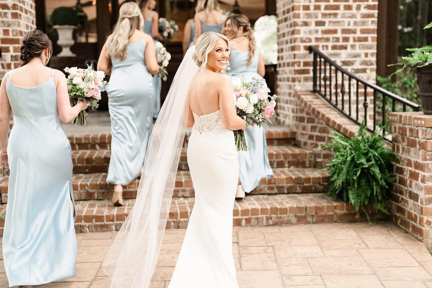 Bride walking down steps with bridesmaids.