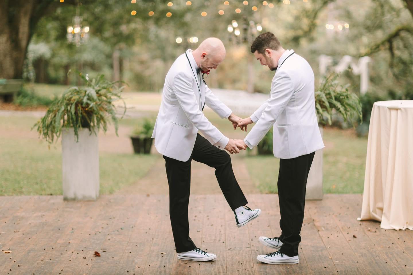 Grooms helping each other with shoes.