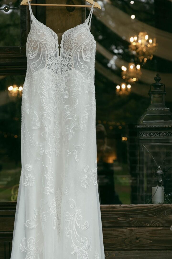 Lace wedding dress hanging on hanger.