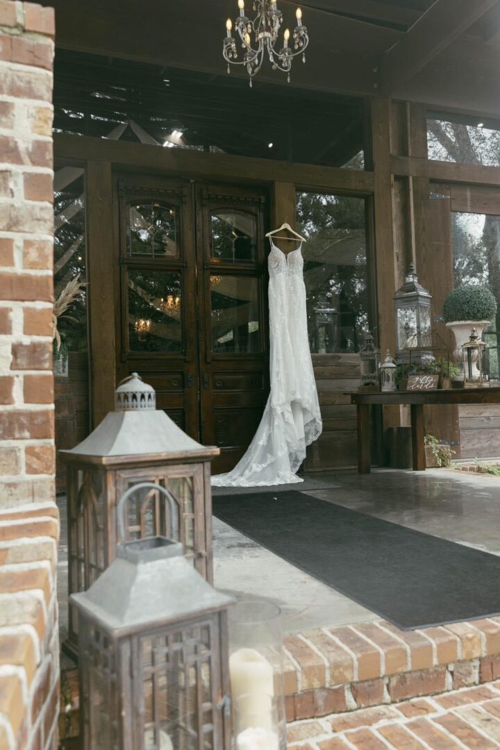 Wedding dress hangs outside rustic venue.