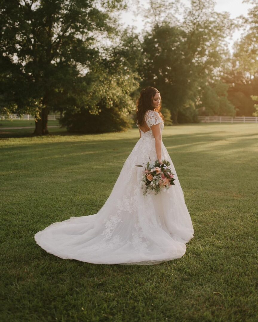 Bride in lace wedding gown outdoors.