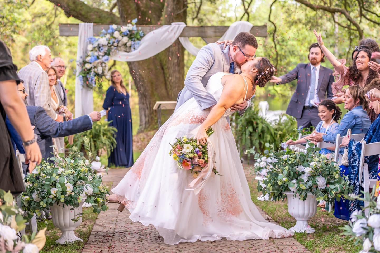 Bride and groom kiss, confetti falls.