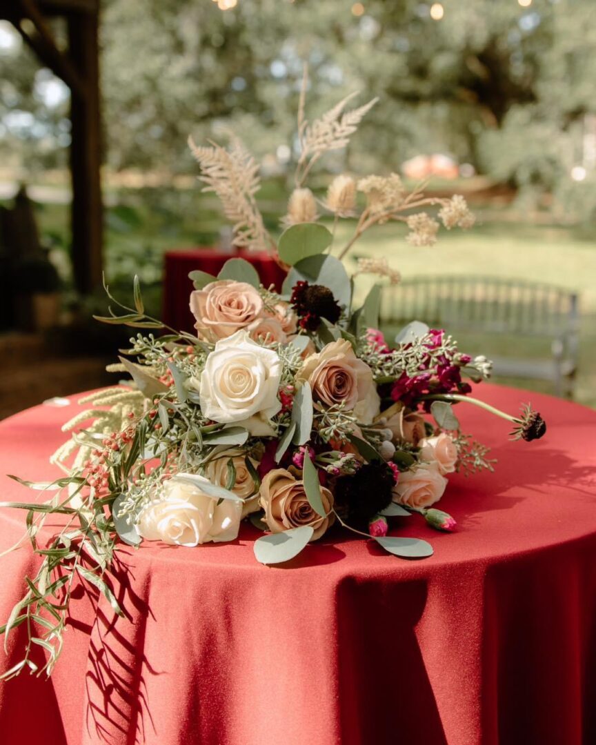 Floral arrangement on red tablecloth.