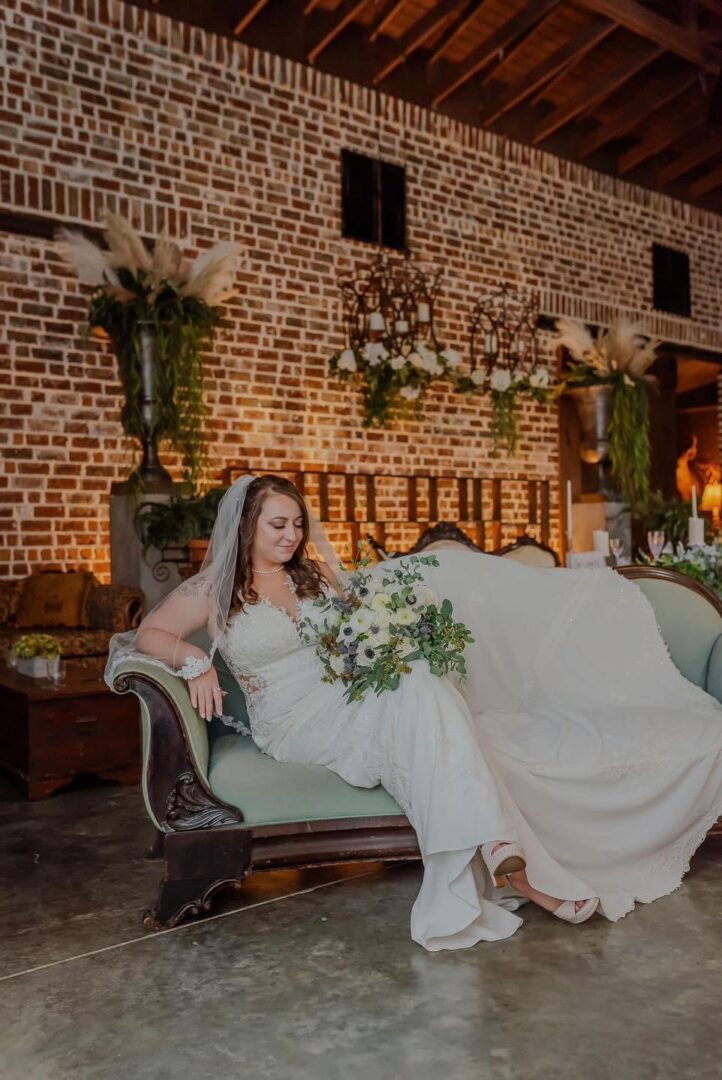 Bride in wedding dress on antique sofa.