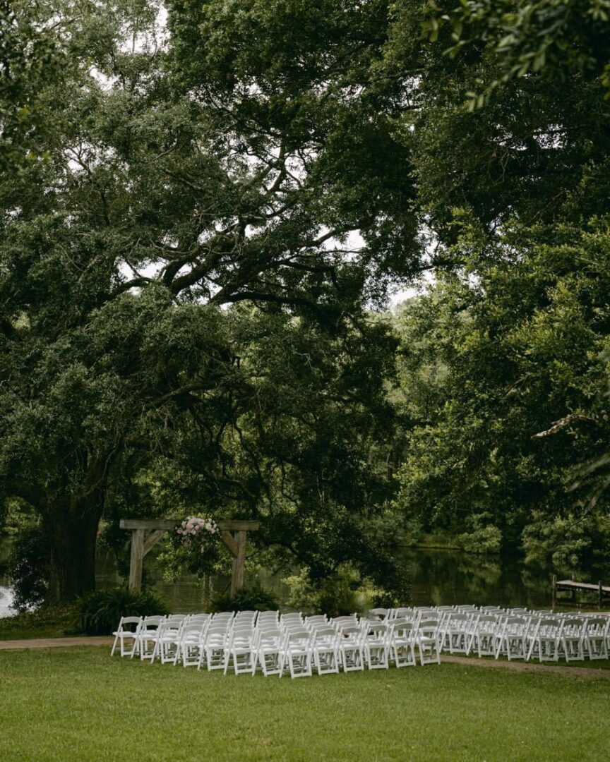 Outdoor wedding ceremony setup by lake.