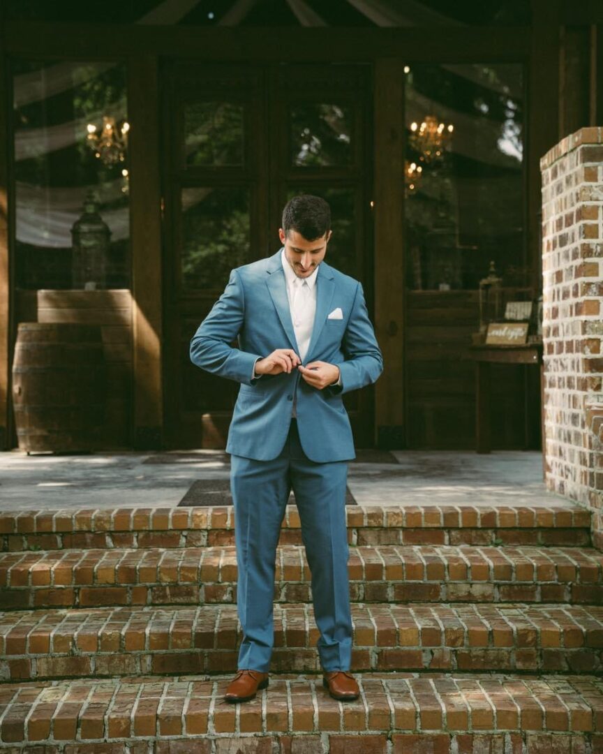 IMG_6195 Groom in blue suit, buttoning jacket.