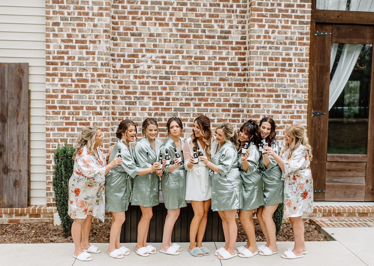 Bridesmaids in robes toasting with mimosas.