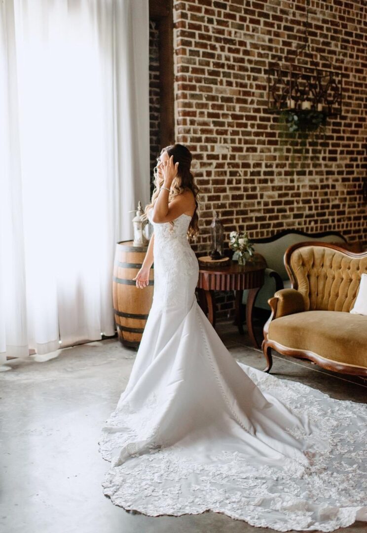 Bride in wedding dress, brick wall.