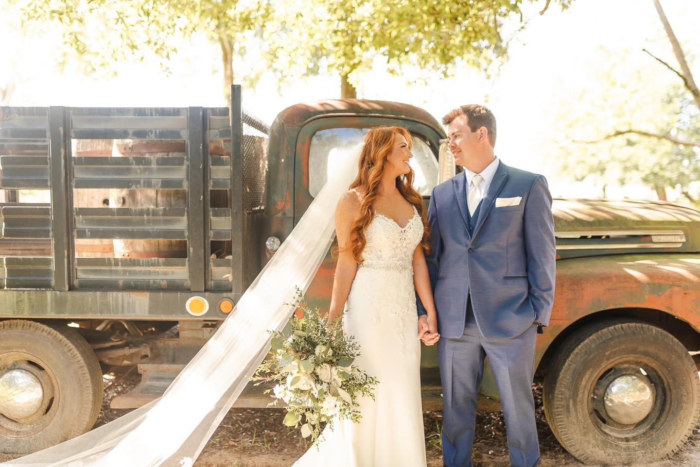 Bride and groom by vintage truck.