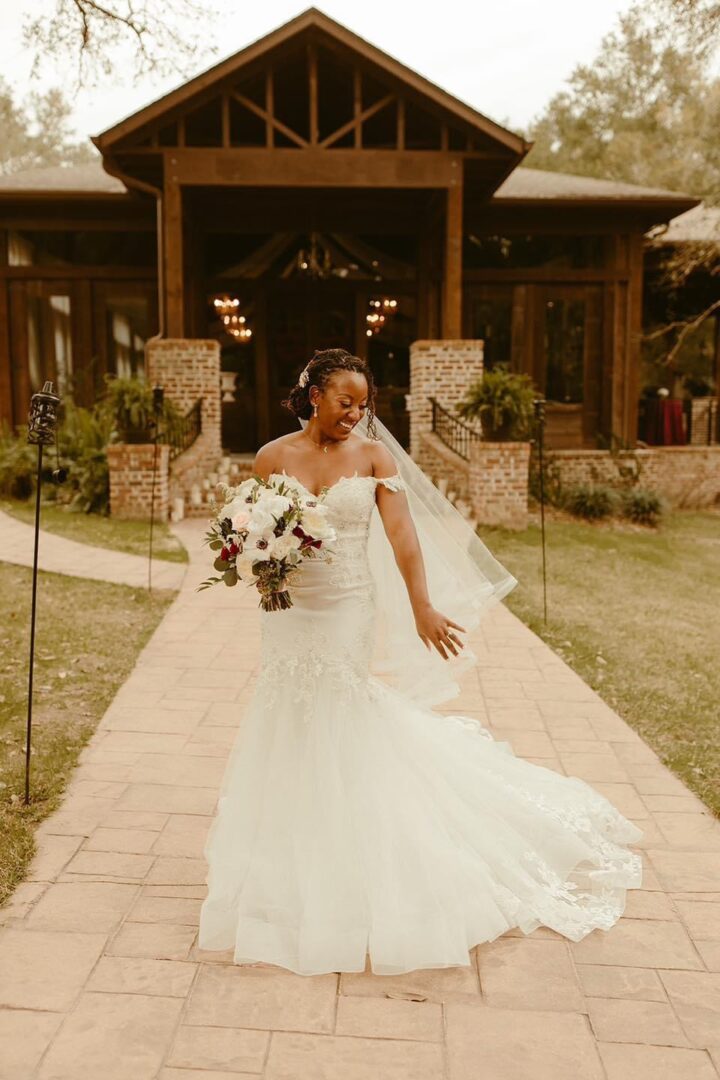 Bride in wedding dress smiles outdoors.