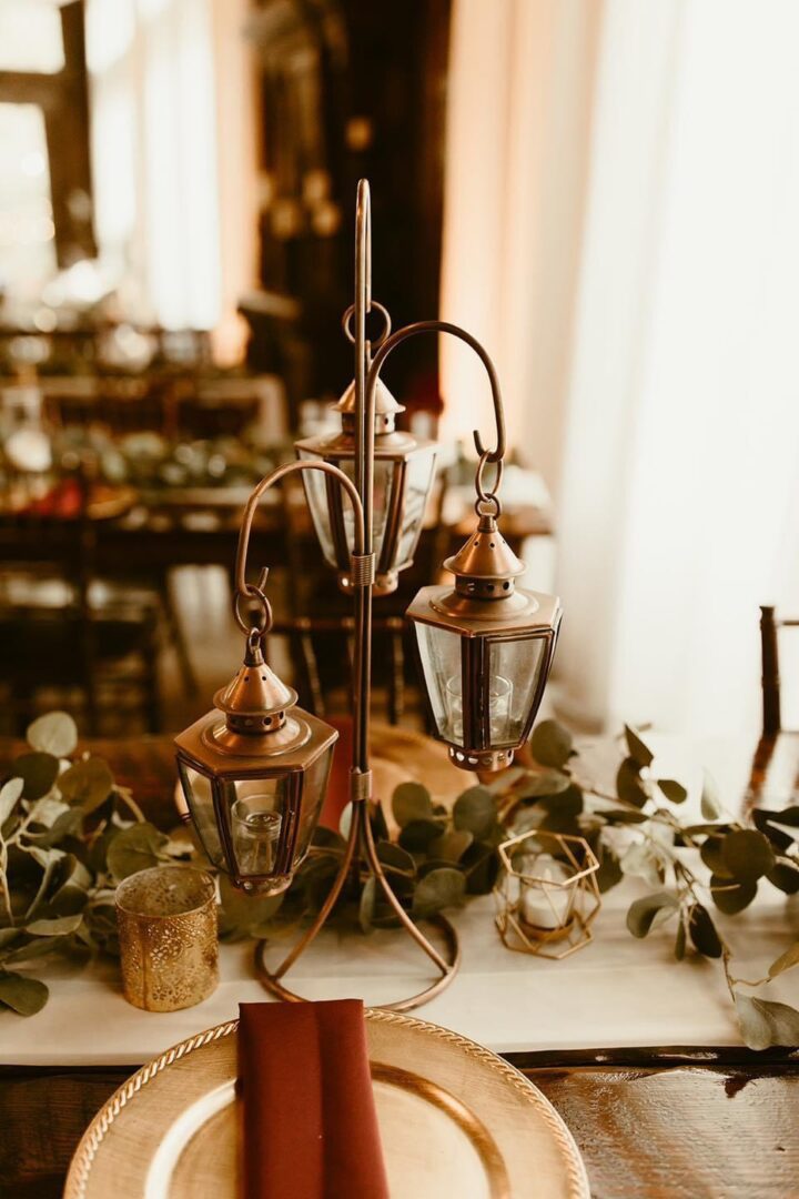 Triple lantern centerpiece with greenery.