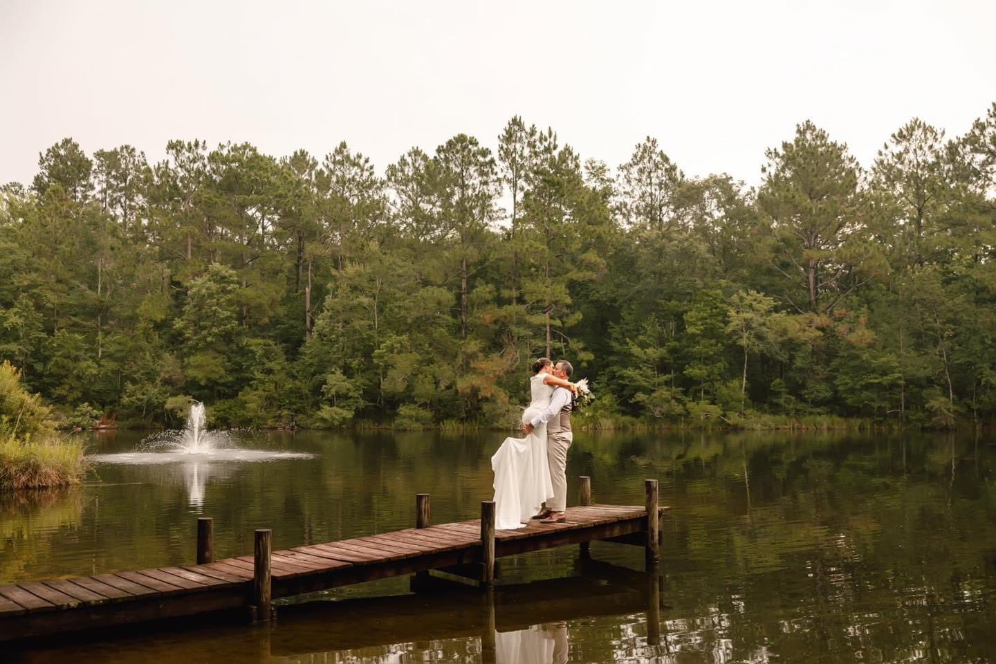 Bride and groom kissing on dock.
