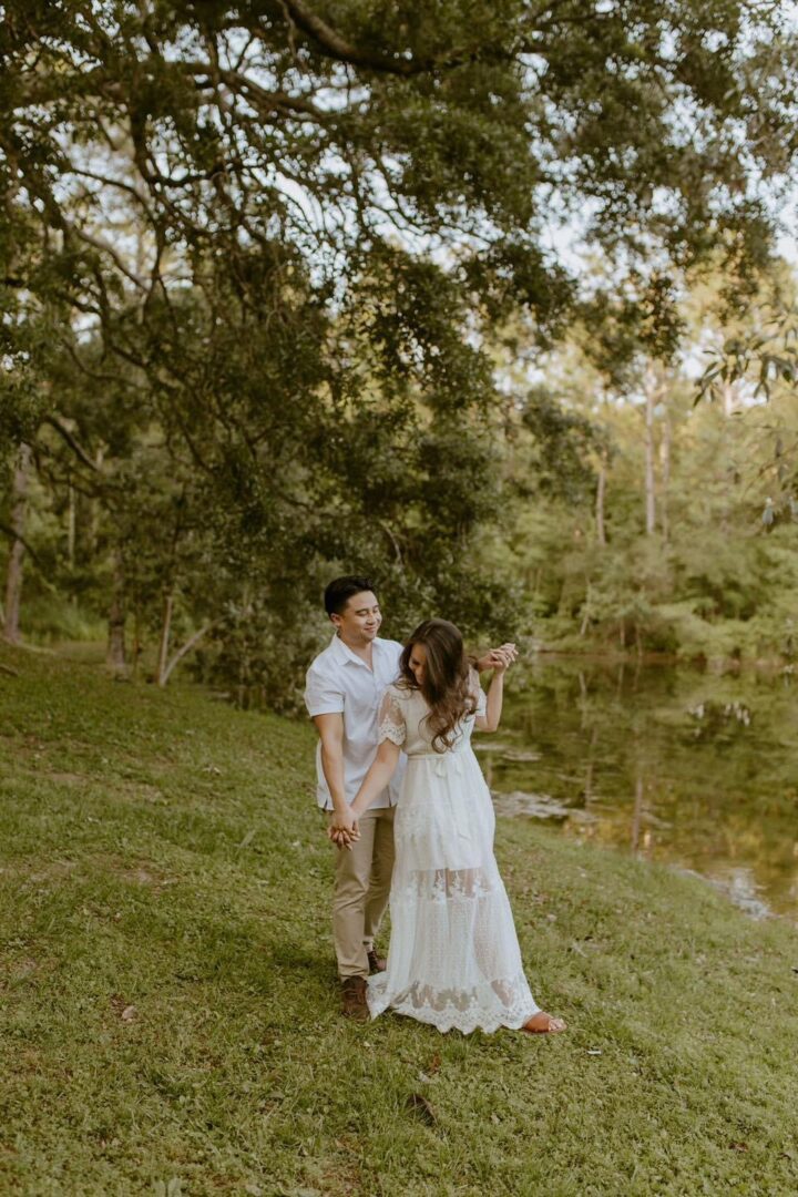 Couple holding hands by a lake.
