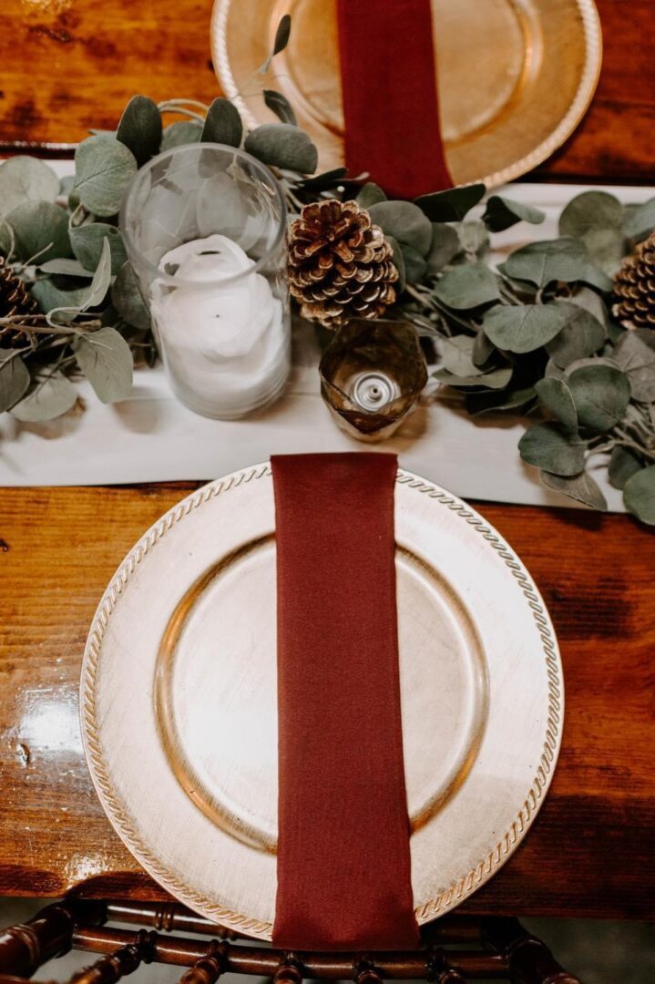 Gold charger, burgundy napkin, holiday table setting.