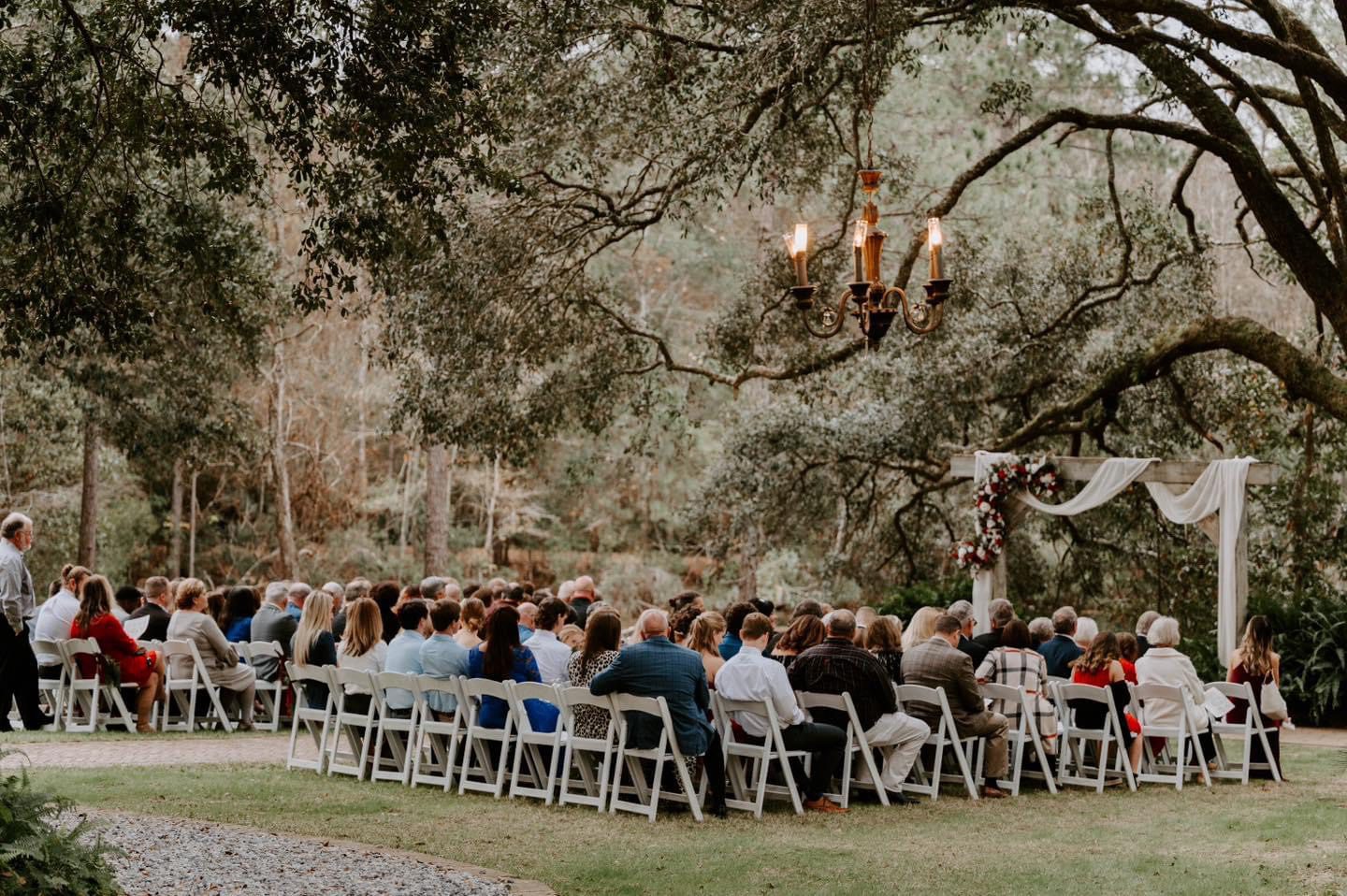 Outdoor wedding ceremony under trees.