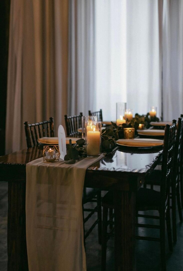 Candles and greenery on a table.