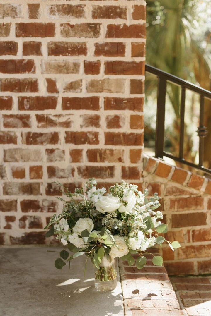 White bridal bouquet near brick wall.