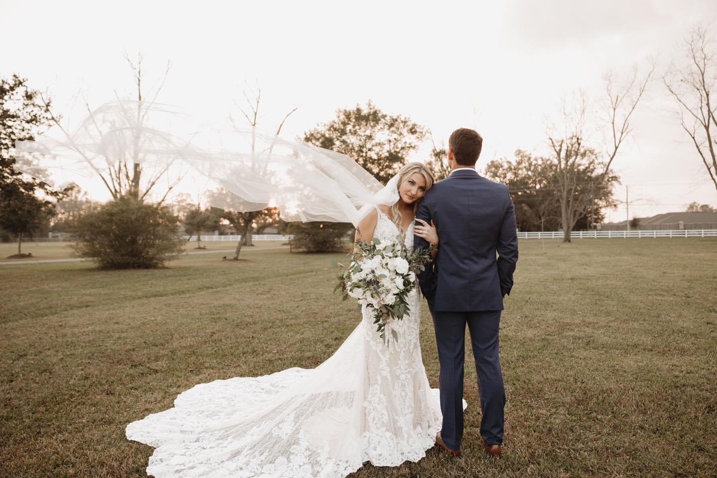 Bride and groom posing outdoors.