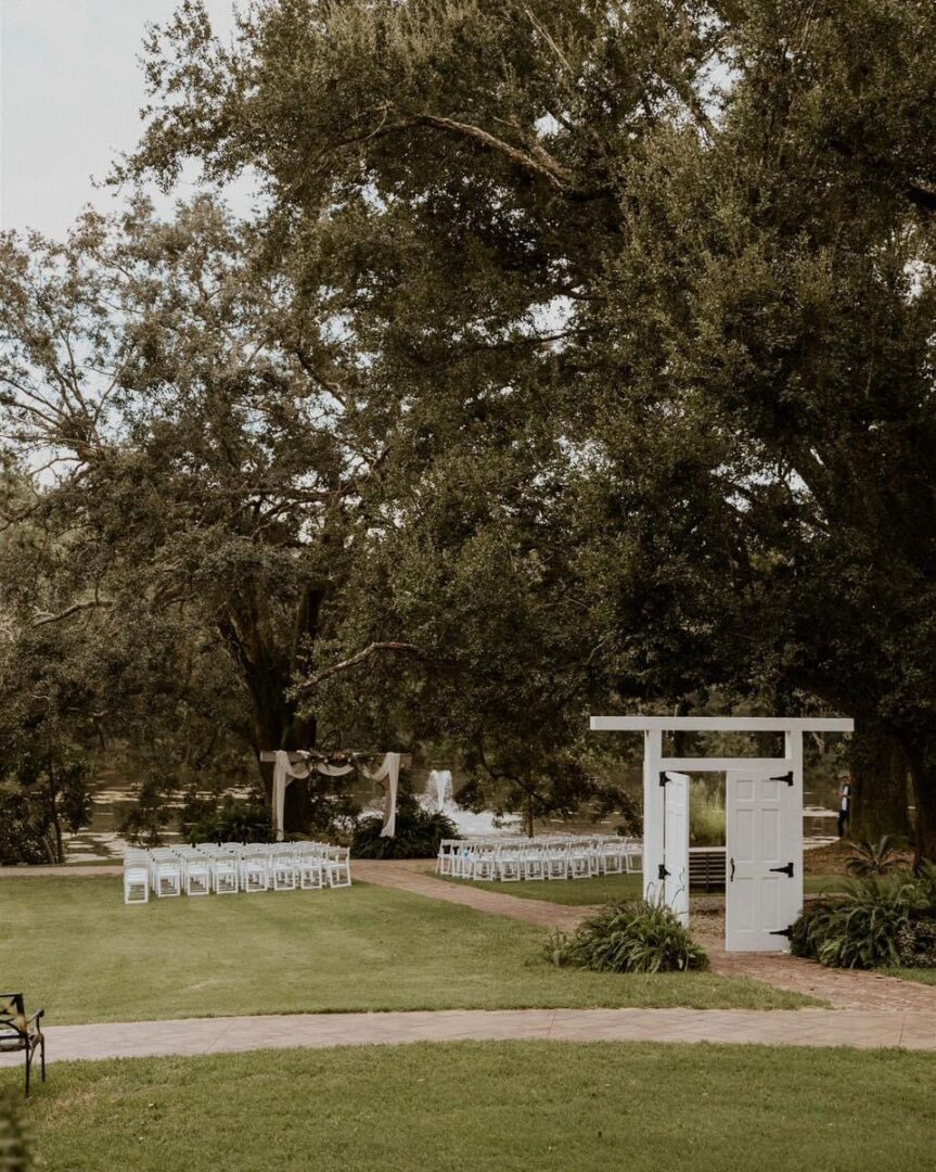 Outdoor wedding ceremony, white chairs, doors.