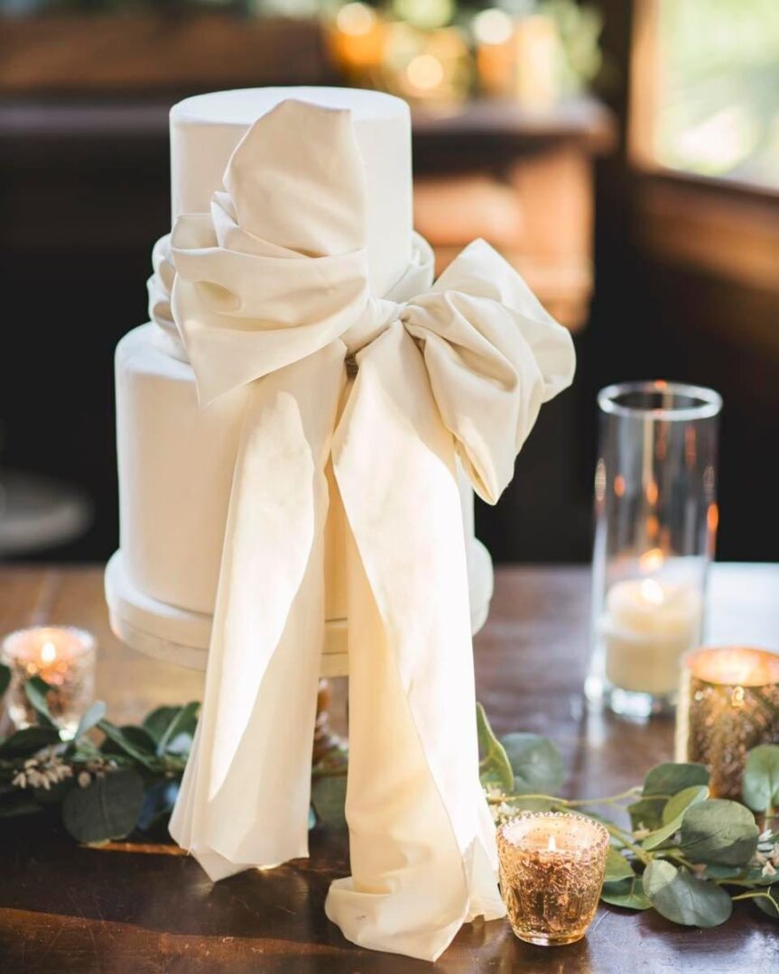 White wedding cake with fabric bow.