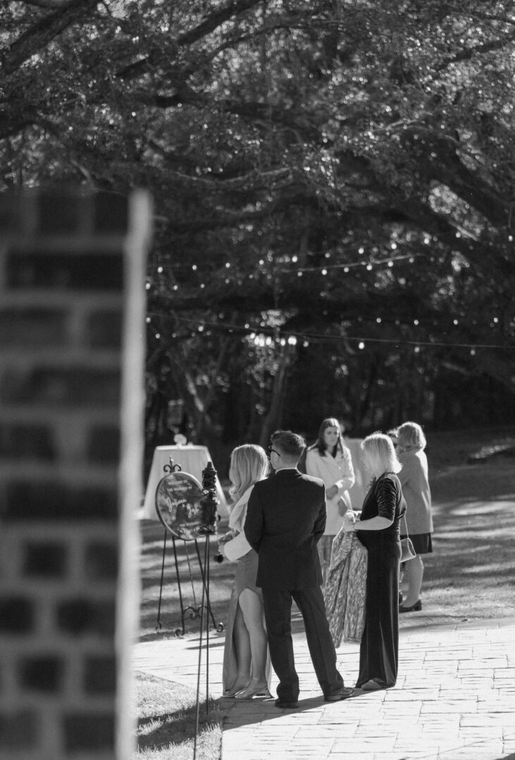 Wedding guests gather outdoors.