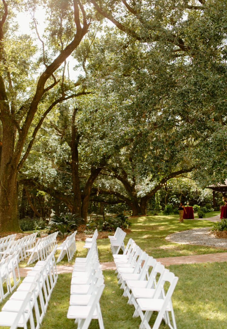 Outdoor wedding ceremony with white chairs.