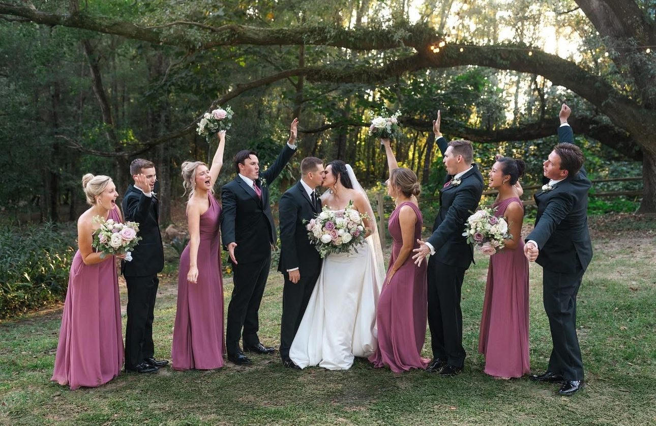 Wedding party celebrating a kiss.