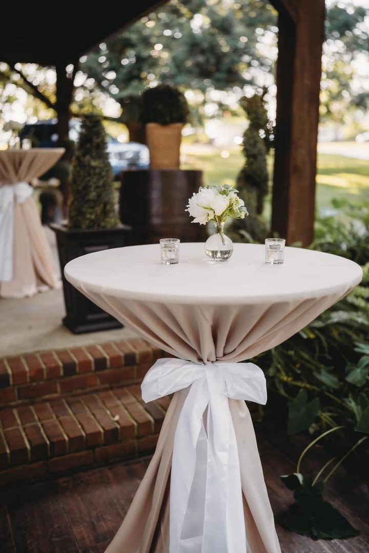 Beige cocktail table with white flowers.