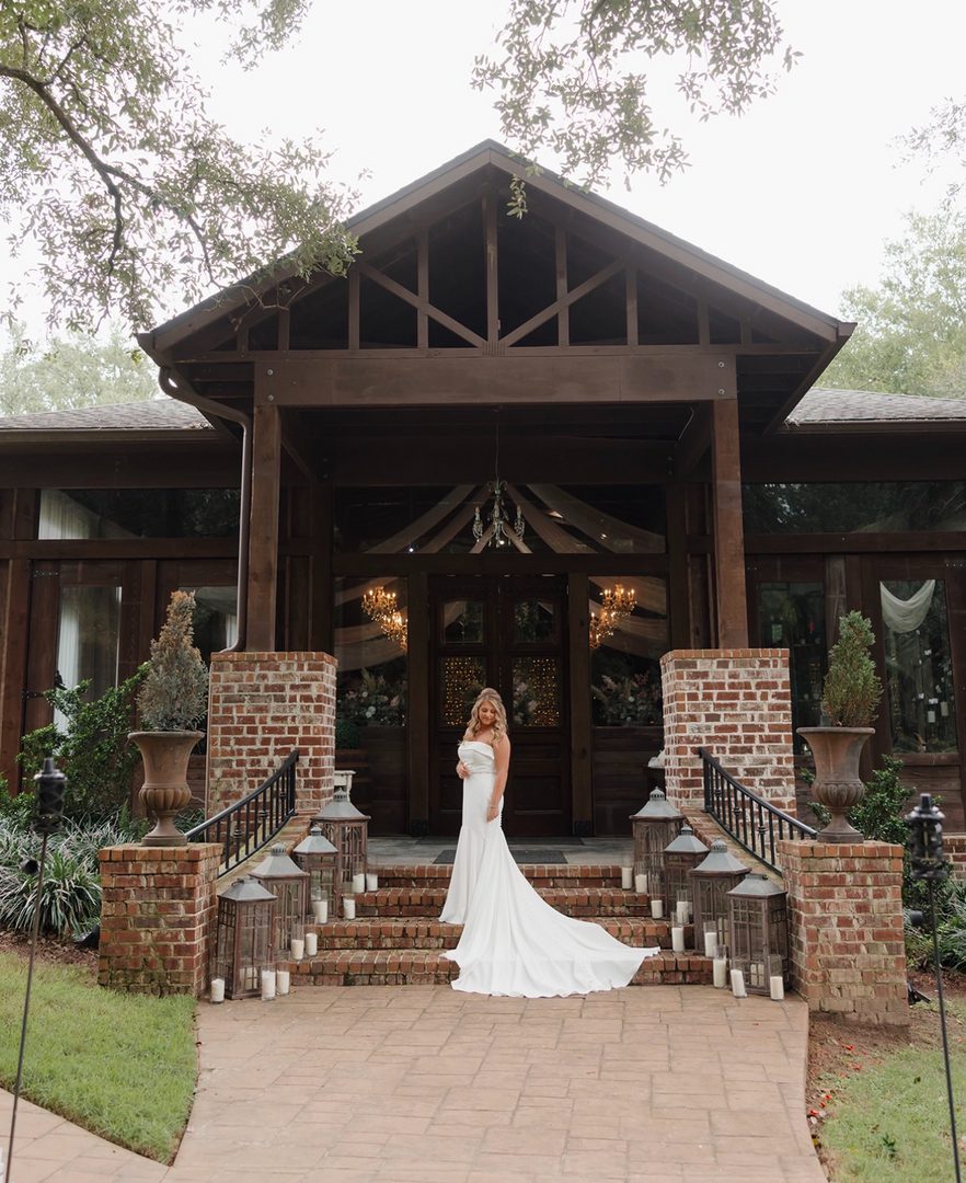 Bride in wedding dress at venue entrance.