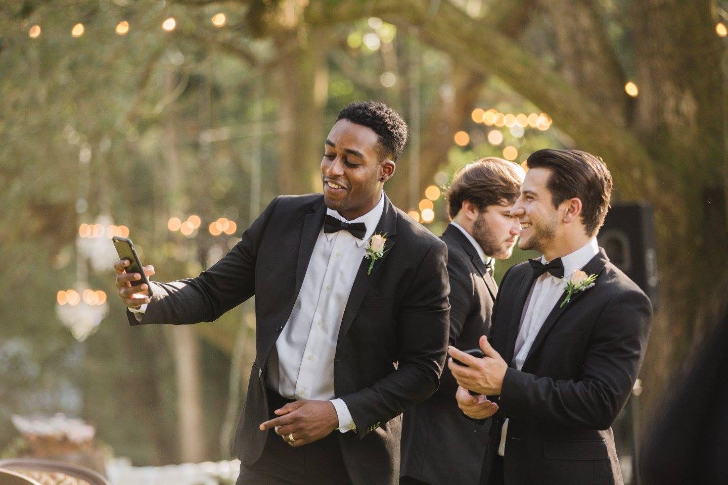 Groomsmen using phones at wedding.
