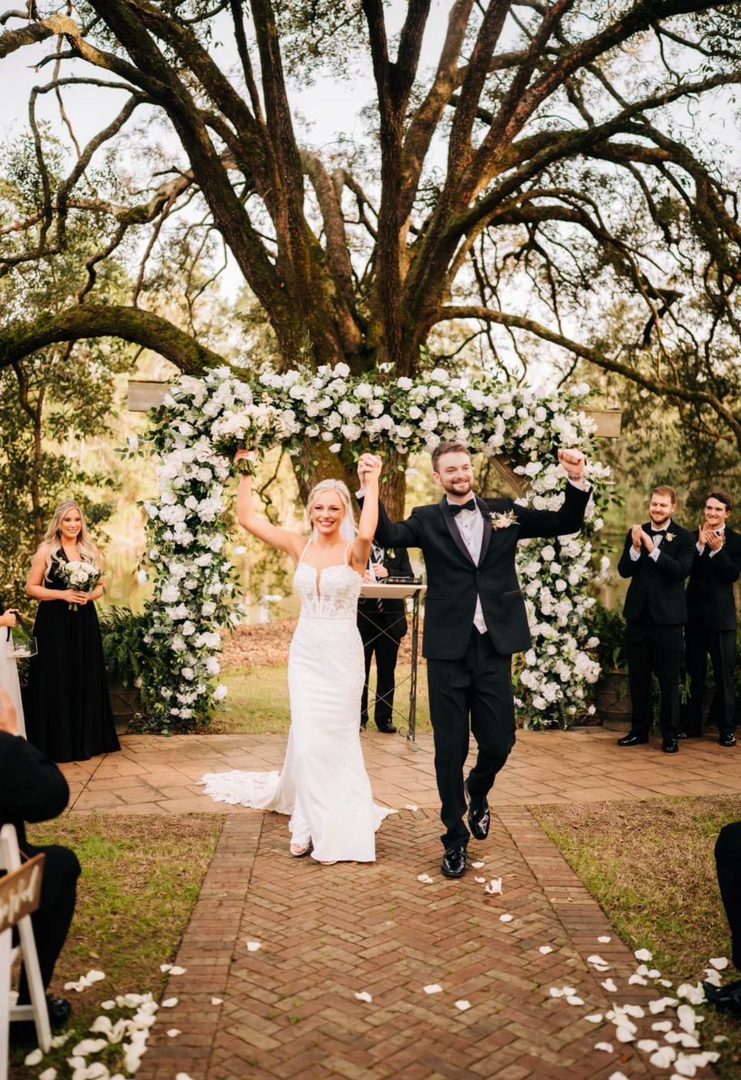 Newlyweds joyfully exit wedding ceremony.