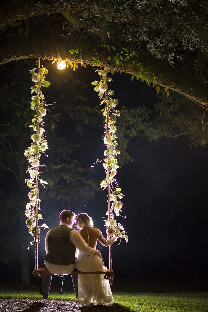Couple embracing on a floral swing.