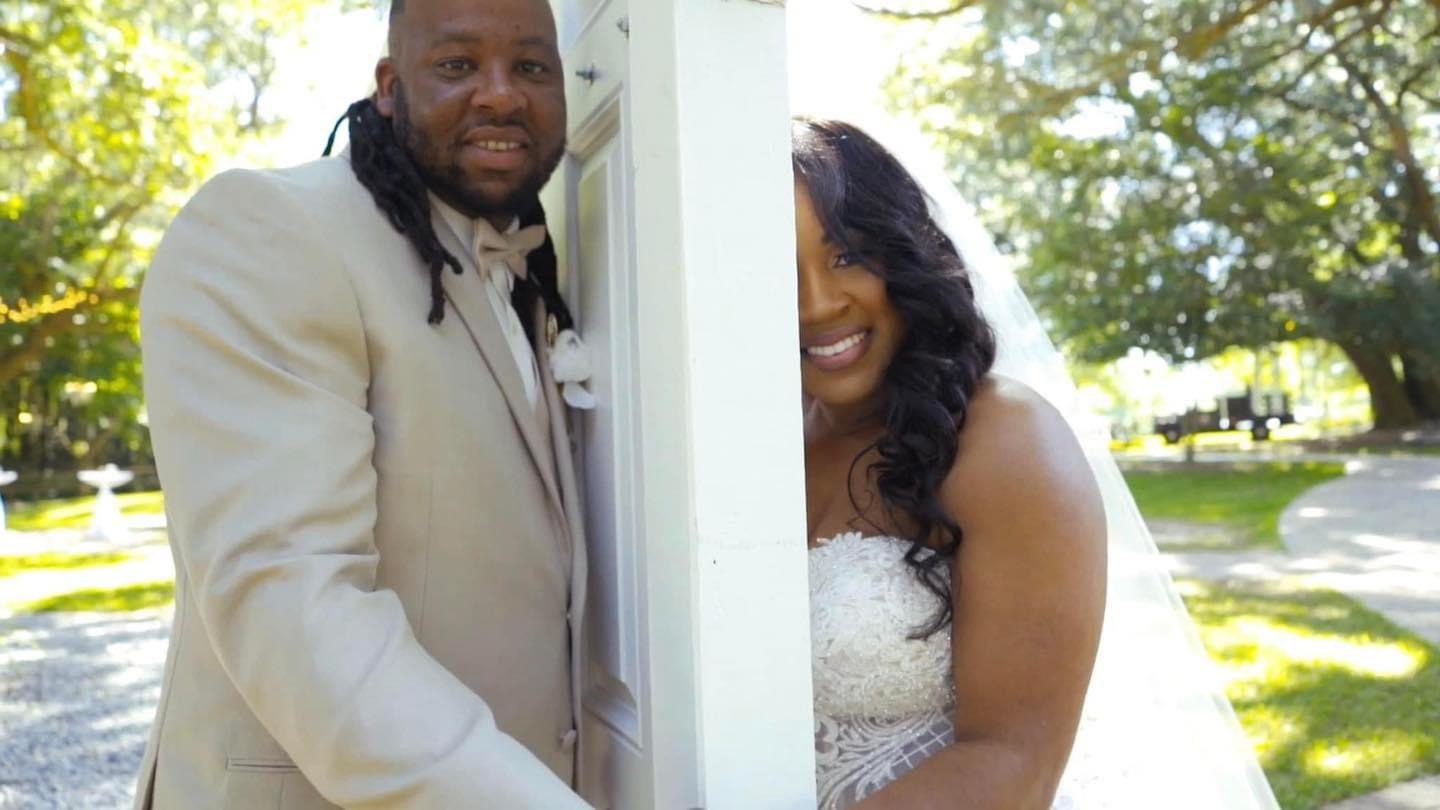 Happy bride and groom peeking around door.
