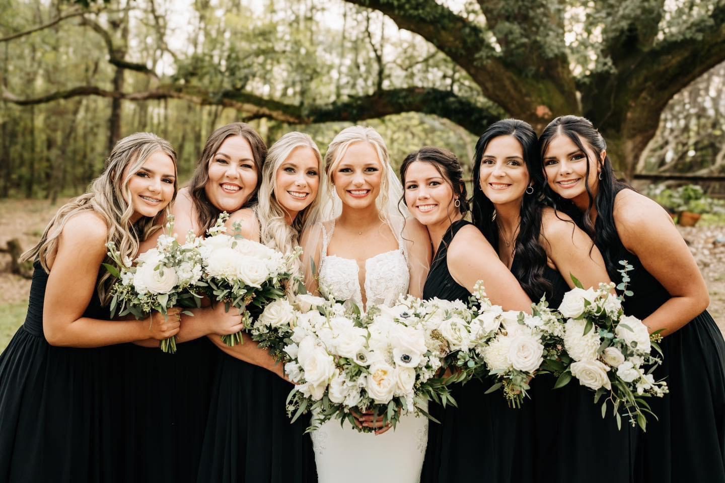 Bride and bridesmaids in black dresses.